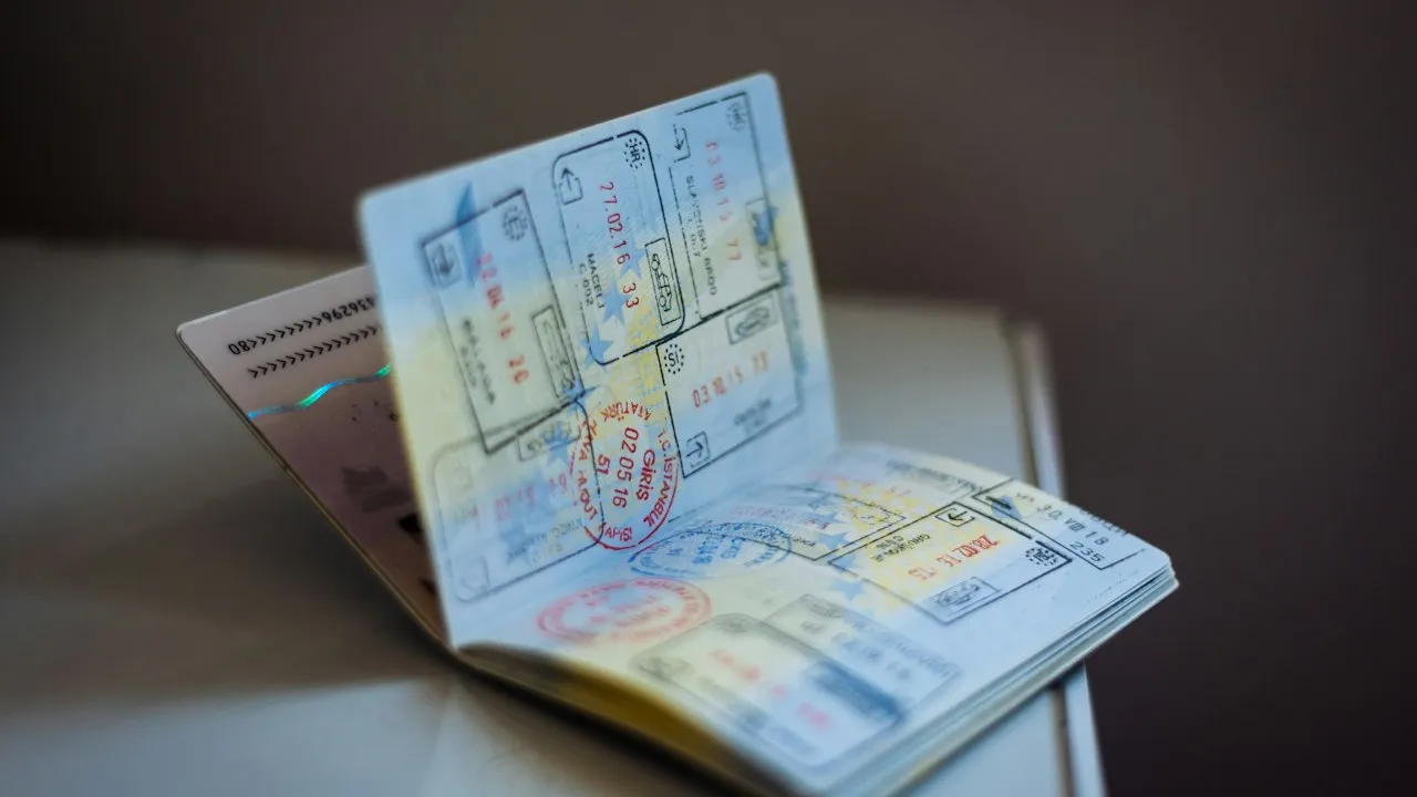 Hộ chiếu mở với nhiều dấu nhập cảnh, minh họa giấy tờ cần đối chiếu khi sửa tên trên thẻ xanh
